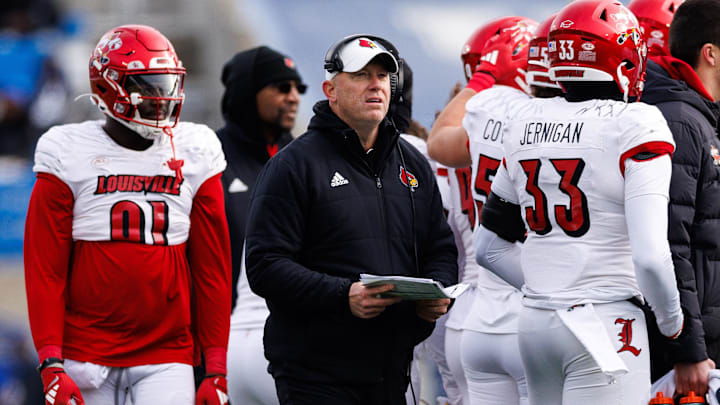 Nov 30, 2024; Lexington, Kentucky, USA; Louisville Cardinals head coach Jeff Brohm joins the team huddle during the third quarter against the Kentucky Wildcats at Kroger Field.