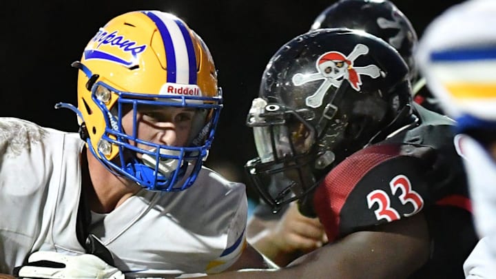 Charlotte High running back Connor Trim (#21) is met at the line of scrimmage by Port Charlotte