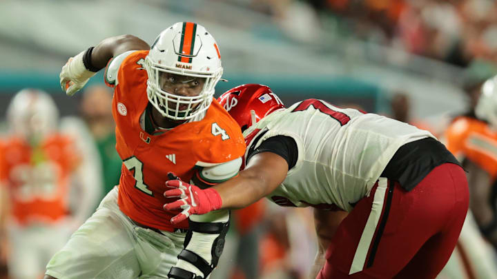 Oct 17, 2025; Miami Gardens, Florida, USA; Miami Hurricanes defensive lineman Rueben Bain Jr. (4) escapes coverage against Louisville Cardinals offensive lineman Trevonte Sylvester (70) during the third quarter at Hard Rock Stadium. Mandatory Credit: Sam Navarro-Imagn Images