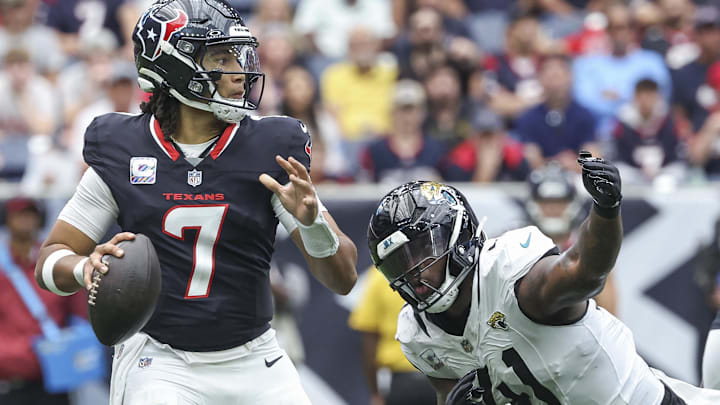 Sep 29, 2024; Houston, Texas, USA; Houston Texans quarterback C.J. Stroud (7) looks for an open receiver as Jacksonville Jaguars defensive end Josh Hines-Allen (41) applies defensive pressure during the second quarter at NRG Stadium. Mandatory Credit: Troy Taormina-Imagn Images