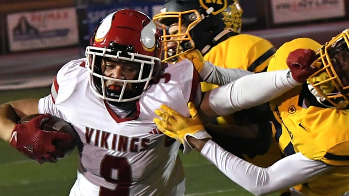 Landen Miree (9) stiff-arms his way to a Princeton first down in the OHSAA Division I football regional semifinals Nov. 15, 2024, at Dwire Field Mason, Ohio.