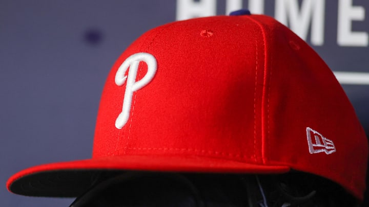 May 26, 2023; Atlanta, Georgia, USA; A detailed view of a Philadelphia Phillies hat and glove on the bench against the Atlanta Braves in the seventh inning at Truist Park.  