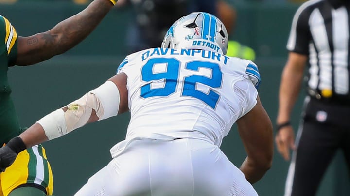 Green Bay Packers running back Josh Jacobs (8) jukes past Detroit Lions defensive end Marcus Davenport (92) 