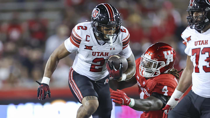 Oct 26, 2024; Houston, Texas, USA; Utah Utes running back Micah Bernard (2) runs with the ball as Houston Cougars defensive back Brandon Mack (4) attempts to make a tackle during the second quarter at TDECU Stadium. Mandatory Credit: Troy Taormina-Imagn Images
