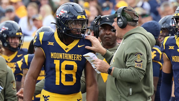 West Virginia University head coach Rich Rodriguez giving instructions to Bandit/running back Curtis Jones Jr. against Colorado.
