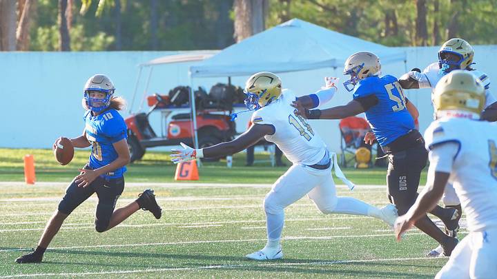Mainland High QB Sebastian Johnson no. 10 looks down field as he scrables under pressure from Osceola's Jason Lewis no. 11, Friday August 15, 2025.