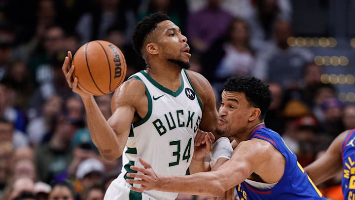 Jan 11, 2026; Denver, Colorado, USA; Milwaukee Bucks forward Giannis Antetokounmpo (34) controls the ball as Denver Nuggets forward Spencer Jones (21) guards in the first quarter at Ball Arena.
