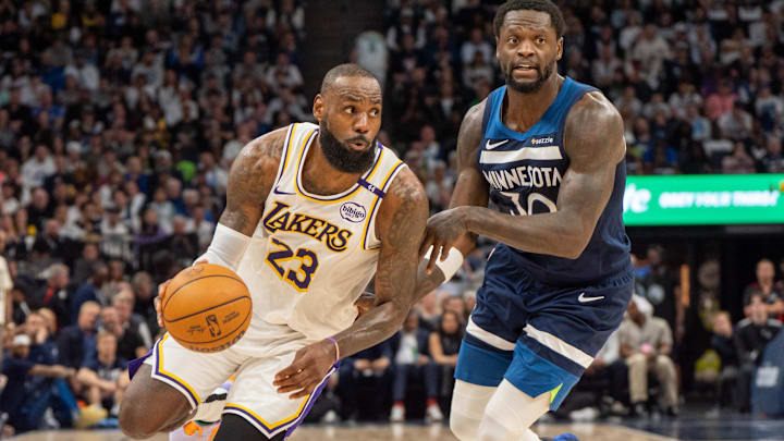 Apr 27, 2025; Minneapolis, Minnesota, USA; Los Angeles Lakers forward LeBron James (23) dribbles past Minnesota Timberwolves forward Julius Randle (30) in the second quarter during game four of first round for the 2025 NBA Playoffs at Target Center. Mandatory Credit: Matt Blewett-Imagn Images