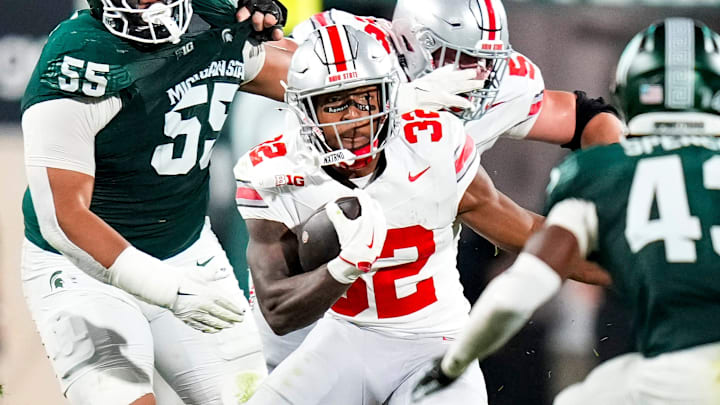 Sep 28, 2024; East Lansing, Michigan, USA; Ohio State Buckeyes running back TreVeyon Henderson (32) runs the ball against Michigan State Spartans defensive back Malik Spencer (43) in the first half at Spartan Stadium on Saturday.