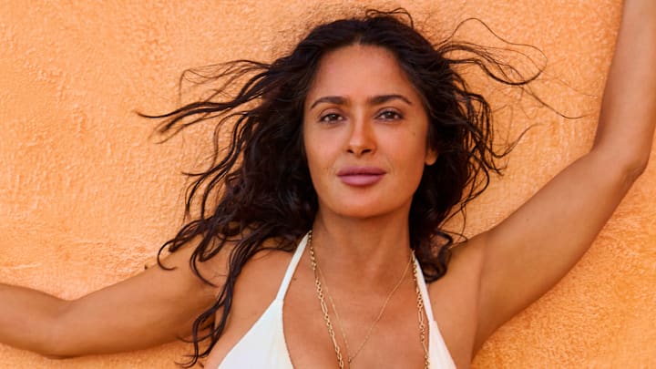 Salma Hayek Pinault was photographed by Ruven Afanador in Mexico. Swimsuit by TJ Swim. Necklace by Foundrae. Body chain by Isa Grutman. Belly chain by Saint Laurent.