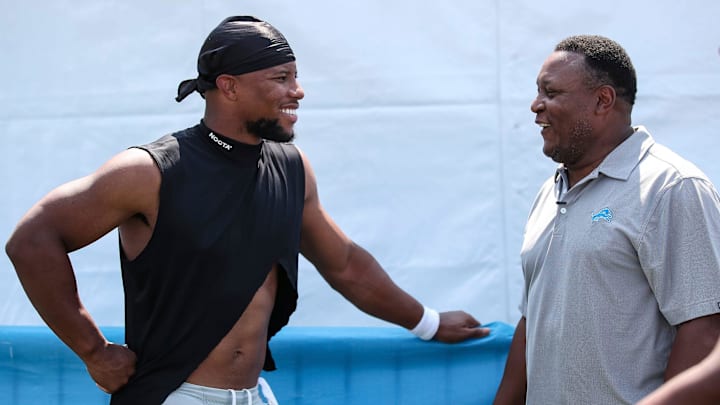Former New York Giants running back Saquon Barkley talks to Lions legend Barry Sanders after joint practices