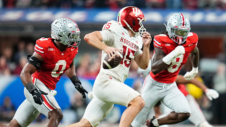 Indiana Hoosiers quarterback Fernando Mendoza (15) scrambles past Ohio State Buckeyes linebacker Sonny Styles (0) and linebacker Arvell Reese (8) during the Big Ten Conference championship game at Lucas Oil Stadium in Indianapolis on Dec. 6, 2025. Ohio State lost 13-10.