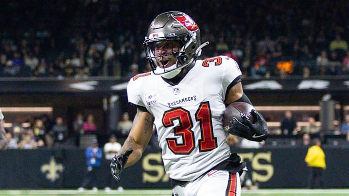 Oct 13, 2024; New Orleans, Louisiana, USA;  Tampa Bay Buccaneers safety Antoine Winfield Jr. (31) return a fumble for a touchdown against New Orleans Saints wide receiver Chris Olave (12) during he first half at Caesars Superdome. Mandatory Credit: Stephen Lew-Imagn Images