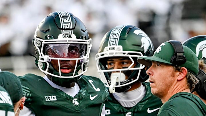 Michigan State's Aidan Chiles, left, and quarterbacks coach Jon Boyer meet on the sideline during the fourth quarter in the game against Youngstown State on Saturday, Sept. 13, 2025, at Spartan Stadium in East Lansing.