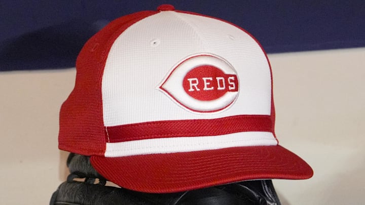 Apr 4, 2025; Milwaukee, Wisconsin, USA; Cincinnati Reds hat and glove rest on the bench in the dugout before a game against the Milwaukee Brewers at American Family Field. Mandatory Credit: Michael McLoone-Imagn Images