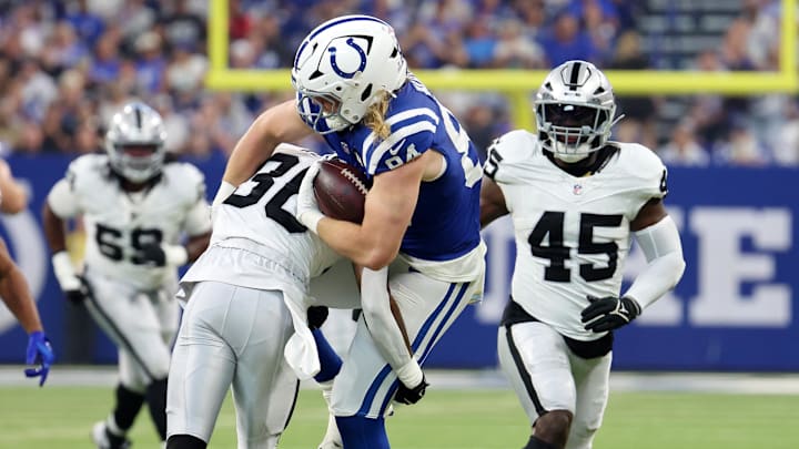Oct 5, 2025; Indianapolis, Indiana, USA; Indianapolis Colts tight end Tyler Warren (84) runs with the ball against Las Vegas Raiders cornerback Darnay Holmes (30) during the first quarter at Lucas Oil Stadium. Mandatory Credit: Trevor Ruszkowski-Imagn Images