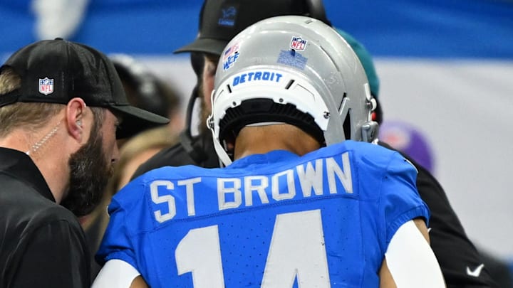 Detroit Lions wide receiver Amon-Ra St. Brown (14) is helped off the field against the Green Bay Packers Detroit Lions wide receiver Amon-Ra St. Brown (14) is helped off the field against the Green Bay Packers