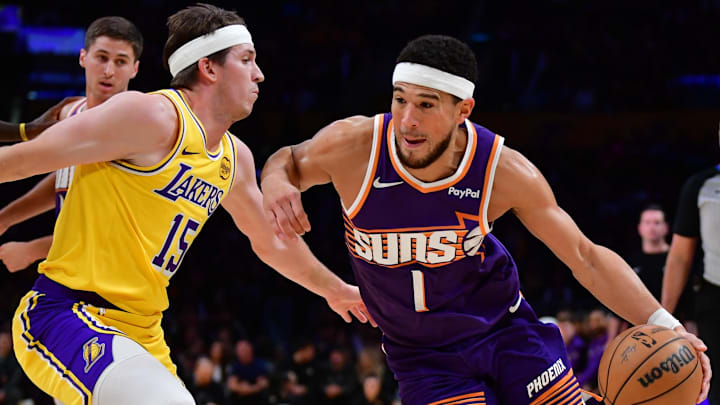 Dec 1, 2025; Los Angeles, California, USA;  Phoenix Suns guard Devin Booker (1) moves the ball against Los Angeles Lakers guard Austin Reaves (15) during the first half at Crypto.com Arena. Mandatory Credit: Gary A. Vasquez-Imagn Images