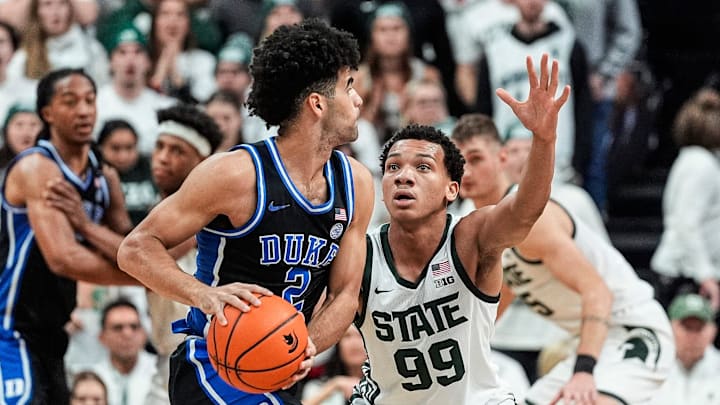 Michigan State guard Divine Ugochukwu (99) defends Duke guard Cayden Boozer (2) during the first half at Breslin Center in East Lansing on Saturday, Dec. 6, 2025.