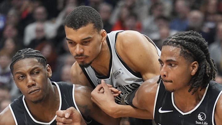 Toronto Raptors forward RJ Barrett and forward Collin Murray-Boyles block out San Antonio Spurs center Victor Wembanyama.