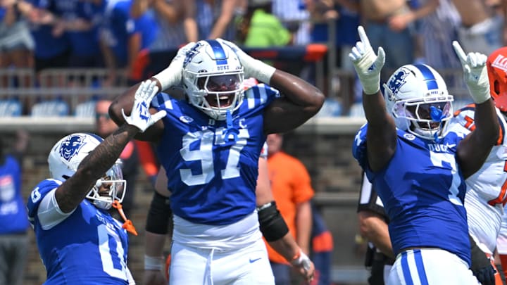 Sep 6, 2025; Durham, North Carolina, USA;  Duke Blue Devils cornerback Chandler Rivers (0), linebacker Jaiden Francois (2) and cornerback Kimari Robinson (5) celebrate a tackle by defensive end Vincent Anthony Jr.'s (7) against the Illinois Fighting Illini during the first quarter at Wallace Wade Stadium. Mandatory Credit: Zachary Taft-Imagn Images