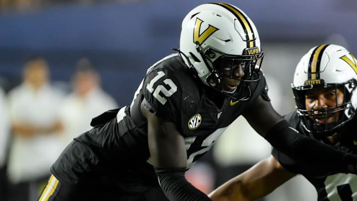 Sep 7, 2024; Nashville, Tennessee, USA;  Vanderbilt Commodores defensive lineman Aeneas DiCosmo (0) and linebacker Jeffrey Ugochukwu (12) tackles Alcorn State Braves quarterback Roderick Hartsfield (11) for a loss during the second half at FirstBank Stadium