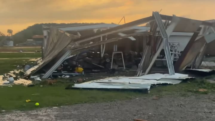 A softball rests in the grass in front of a destroyed facility that appeared to house sports equipment at Gordon High School after violent storms - and a suspected tornado - devastated much of the campus on Sunday night, May 18, 2025. 