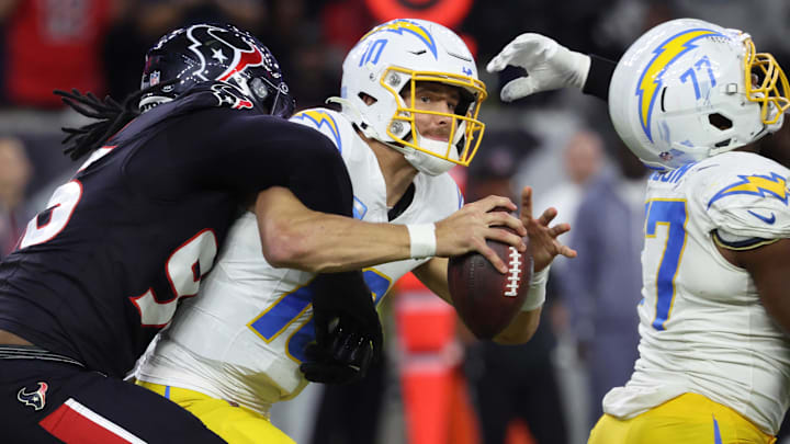 Jan 11, 2025; Houston, Texas, USA; Los Angeles Chargers quarterback Justin Herbert (10) is sacked by Houston Texans defensive end Denico Autry (96) during the third quarter in an AFC wild card game at NRG Stadium. Mandatory Credit: Troy Taormina-Imagn Images