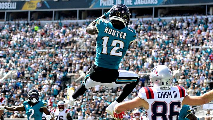 Sep 27, 2026; Jacksonville, Florida, USA;  Jacksonville Jaguars wide receiver Travis Hunter (12) intercepts a pass during the second quarter against the New England Patriots at EverBank Stadium.  