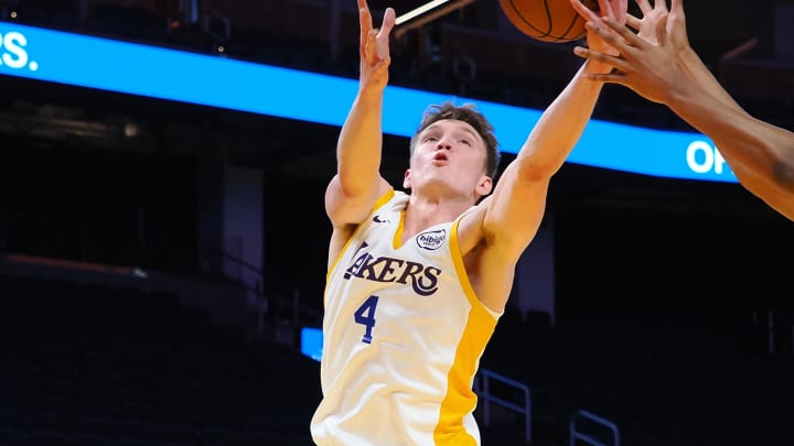 Jul 10, 2024; San Francisco, CA, USA; Los Angeles Lakers guard Dalton Knecht (4) extends for a rebound against the Miami Heat forward JC Butler (57) during the first quarter at Chase Center. Mandatory Credit: Kelley L Cox-USA TODAY Sports