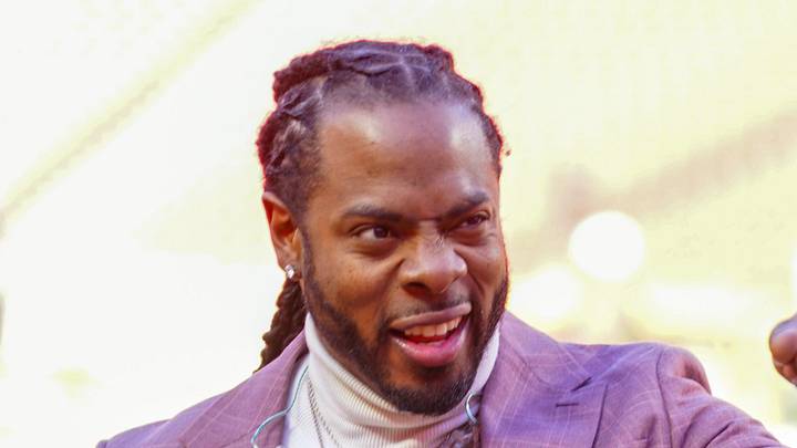 Former Seattle Seahawks cornerback Richard Sherman signals to fans