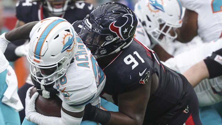 Dec 15, 2024; Houston, Texas, USA; Houston Texans defensive tackle Folorunso Fatukasi (91) attempts to tackle Miami Dolphins running back De'Von Achane (28) during the first quarter at NRG Stadium. Mandatory Credit: Troy Taormina-Imagn Images Dec 15, 2024; Houston, Texas, USA; Houston Texans defensive tackle Folorunso Fatukasi (91) attempts to tackle Miami Dolphins running back De'Von Achane (28) during the first quarter at NRG Stadium. Mandatory Credit: Troy Taormina-Imagn Images