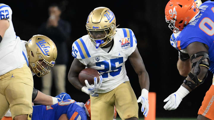 Dec 16, 2023; Inglewood, CA, USA; UCLA Bruins running back TJ Harden (25) runs through a hole in the line of scrimmage against the Boise State Broncos during the fourth quarter in the Starco Brands LA Bowl at SoFi Stadium. Mandatory Credit: Robert Hanashiro-Imagn Images