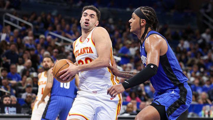 Apr 15, 2025; Orlando, Florida, USA; Atlanta Hawks forward Georges Niang (20) drives to the basket against past Orlando Magic forward Paolo Banchero (5) in the second quarter at Kia Center. Mandatory Credit: Nathan Ray Seebeck-Imagn Images