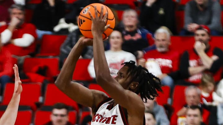 Dec 6, 2025; Raleigh, North Carolina, USA; NC State Wolfpack guard Jr. Paul McNeil (2) shoots a 3-point shot past Liberty Flames guard Kaden Metheny (3) during the second half of the game at Lenovo Center. Mandatory Credit: Jaylynn Nash-Imagn Images