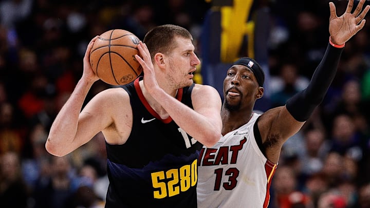 Feb 29, 2024; Denver, Colorado, USA; Denver Nuggets center Nikola Jokic (15) controls the ball as Miami Heat center Bam Adebayo (13) guards in the fourth quarter at Ball Arena.