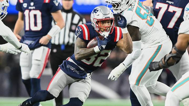 Jan 4, 2026; Foxborough, Massachusetts, USA; New England Patriots running back TreVeyon Henderson (32) runs the ball against Miami Dolphins center Aaron Brewer (55) during the first quarter at Gillette Stadium. Mandatory Credit: Brian Fluharty-Imagn Images Jan 4, 2026; Foxborough, Massachusetts, USA; New England Patriots running back TreVeyon Henderson (32) runs the ball against Miami Dolphins center Aaron Brewer (55) during the first quarter at Gillette Stadium. Mandatory Credit: Brian Fluharty-Imagn Images