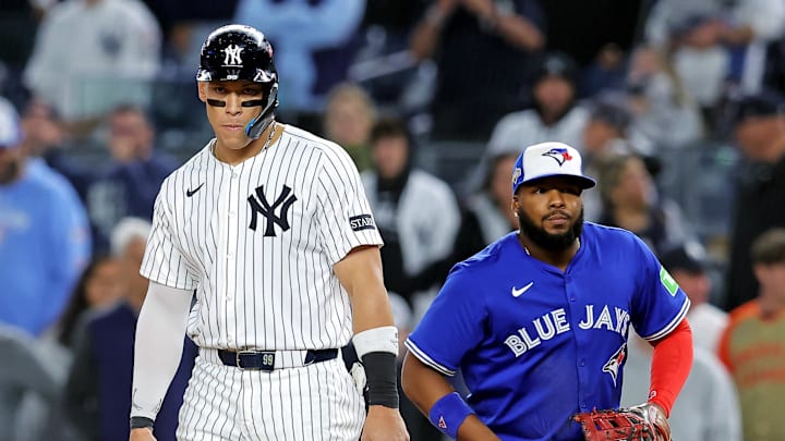 Oct 8, 2025; Bronx, New York, USA; New York Yankees right fielder Aaron Judge (99) stands on first base with Toronto Blue Jays first baseman Vladimir Guerrero Jr. (27) during the ninth inning during game four of the ALDS round for the 2025 MLB playoffs at Yankee Stadium. Mandatory Credit: Brad Penner-Imagn Images