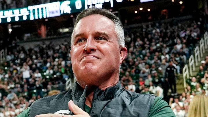 Michigan State's new football coach Pat Fitzgerald pats his heart at the crowd in attendance for the Spartans basketball game against Iowa on Tuesday, Dec. 2, 2025, at the Breslin Center in East Lansing. Michigan State's new football coach Pat Fitzgerald pats his heart at the crowd in attendance for the Spartans basketball game against Iowa on Tuesday, Dec. 2, 2025, at the Breslin Center in East Lansing.