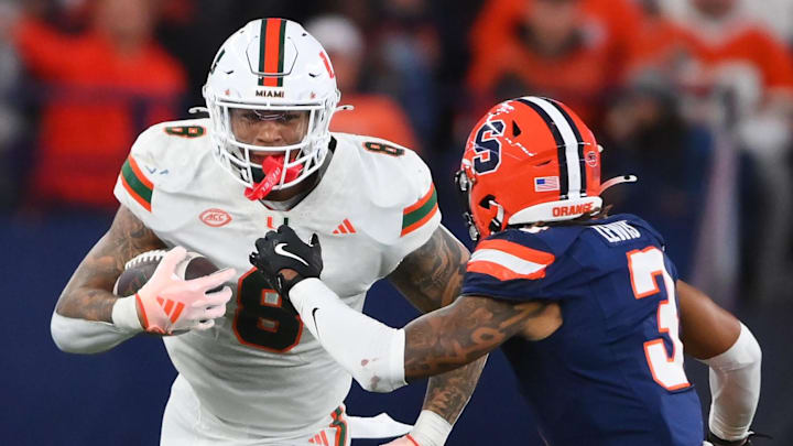 Nov 30, 2024; Syracuse, New York, USA; Miami Hurricanes tight end Elijah Arroyo (8) runs with the ball after a catch against Syracuse Orange defensive back Clarence Lewis (3) during the second half at the JMA Wireless Dome.