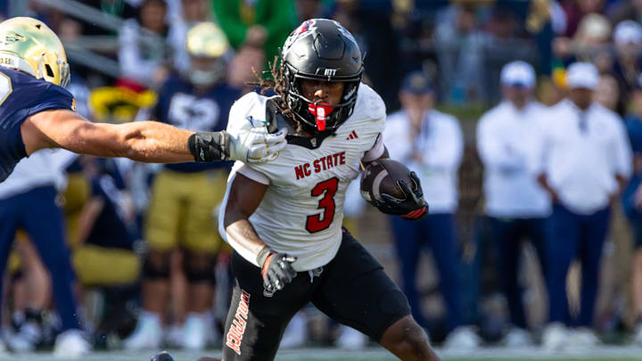 Oct 11, 2025; South Bend, Indiana, USA; NC State Wolfpack running back Hollywood Smothers (3) tries to break a tackle attempt by Notre Dame Fighting Irish linebacker Joshua Burnham (40) during the first half at Notre Dame Stadium. Mandatory Credit: Michael Caterina-Imagn Images
