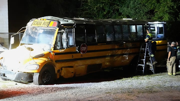 Tape is applied over broken windows on the school bus involved in crash with Minco softball team at Norwood Wrecker Service early Tuesday, Sep. 9, 2025 in Union City, Oklahoma.