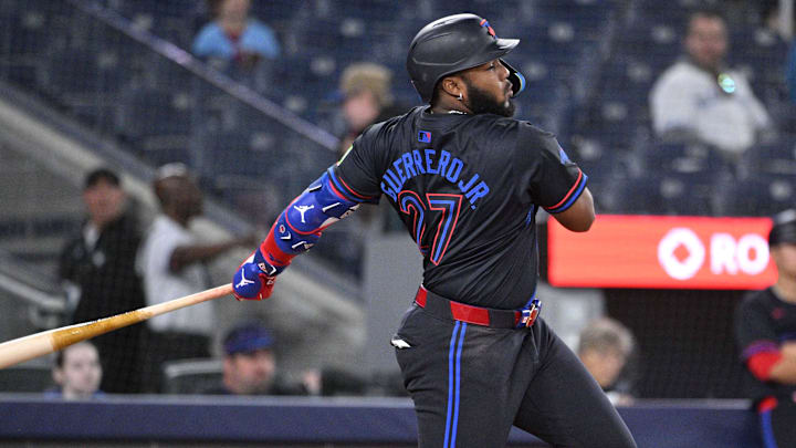 Aug 21, 2024; Toronto, Ontario, CAN;  Toronto Blue Jays third baseman Vladimir Guererro Jr. (27) hits a single against the Cincinnati Reds in the ninth inning at Rogers Centre. 