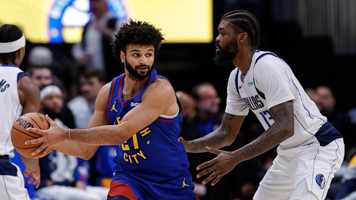 Dec 1, 2025; Denver, Colorado, USA; Denver Nuggets guard Jamal Murray (27) controls the ball under pressure from Dallas Mavericks forward Naji Marshall (13) in the third quarter at Ball Arena.