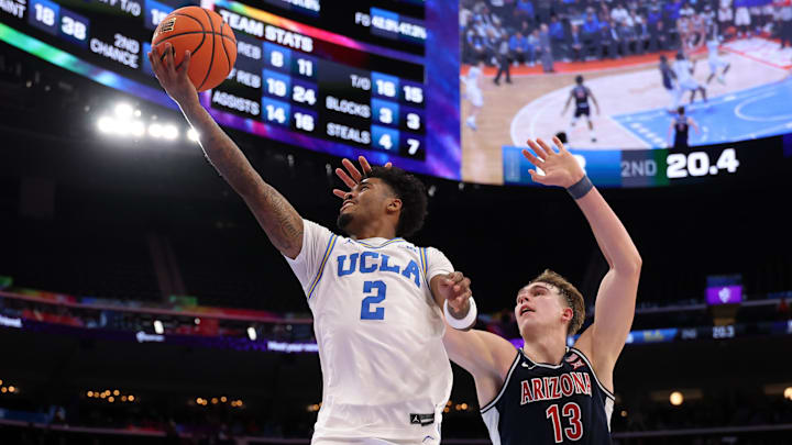 Nov 14, 2025; Inglewood, California, USA;  UCLA Bruins guard Donovan Dent (2) goes to the basket past Arizona Wildcats center Motiejus Krivas (13) during the second half of the Hall of Fame Series game at Intuit Dome. Mandatory Credit: Kiyoshi Mio-Imagn Images