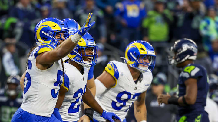 Nov 3, 2024; Seattle, Washington, USA; Los Angeles Rams safety Kamren Kinchens (26) celebrates following an interception against Seattle Seahawks quarterback Geno Smith (7, background second from right) during the fourth quarter at Lumen Field. Mandatory Credit: Joe Nicholson-Imagn Images