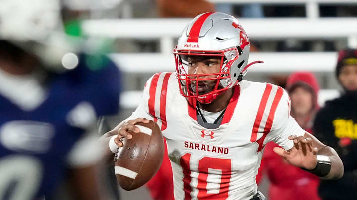Saraland's Jamison Roberts (10) escapes a pass rush to throw a touchdown pass at the end of the first half against Clay-Chalkville at Protective Life Stadium in the AHSAA 6A State Championship game.