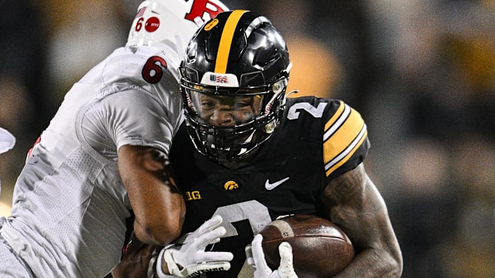 Nov 11, 2023; Iowa City, Iowa, USA; Iowa Hawkeyes running back Kaleb Johnson (2) runs the ball as Rutgers Scarlet Knights defensive back Shaquan Loyal (6) goes for the tackle during the fourth quarter at Kinnick Stadium. Mandatory Credit: Jeffrey Becker-Imagn Images