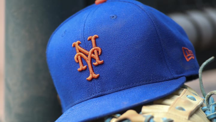 Jul 13, 2022; Atlanta, Georgia, USA; A detailed view of a New York Mets hat and glove in the dugout against the Atlanta Braves in the eighth inning at Truist Park. 