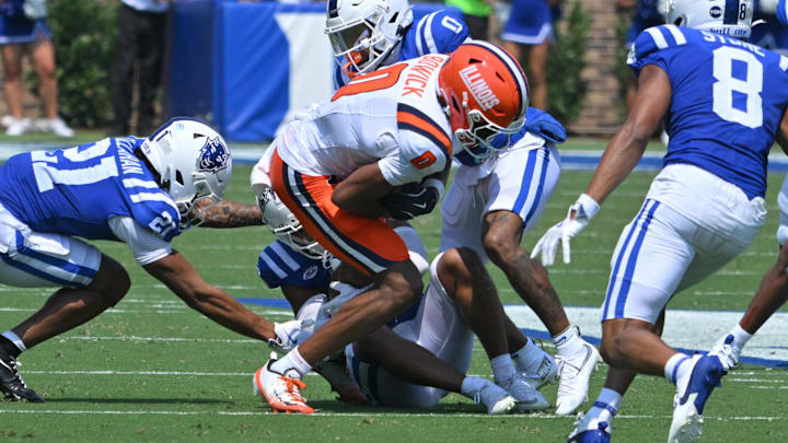Sep 6, 2025; Durham, North Carolina, USA;  Illinois Fighting Illini wide receiever Justin Bowick (0) is tackled by Duke Blue Devils saftey Caleb Weaver (3) and cornerback Chandler Rivers (0) during the second quarter at Wallace Wade Stadium. Mandatory Credit: Zachary Taft-Imagn Images